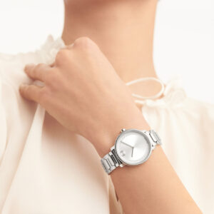 moteris dėvi sidabrinį prabangų laikrodį su baltu ciferblateliu